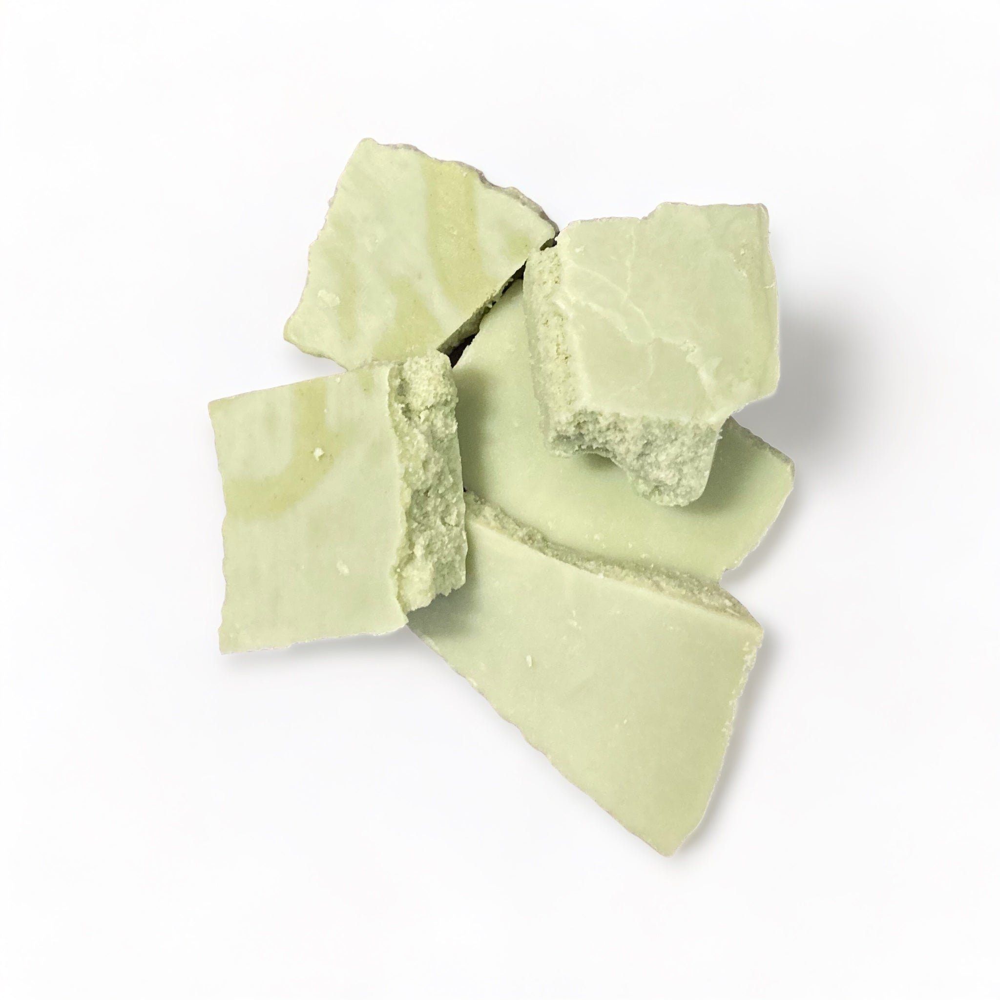 Pale green soy wax in bark form in Pear fragrance on a white background