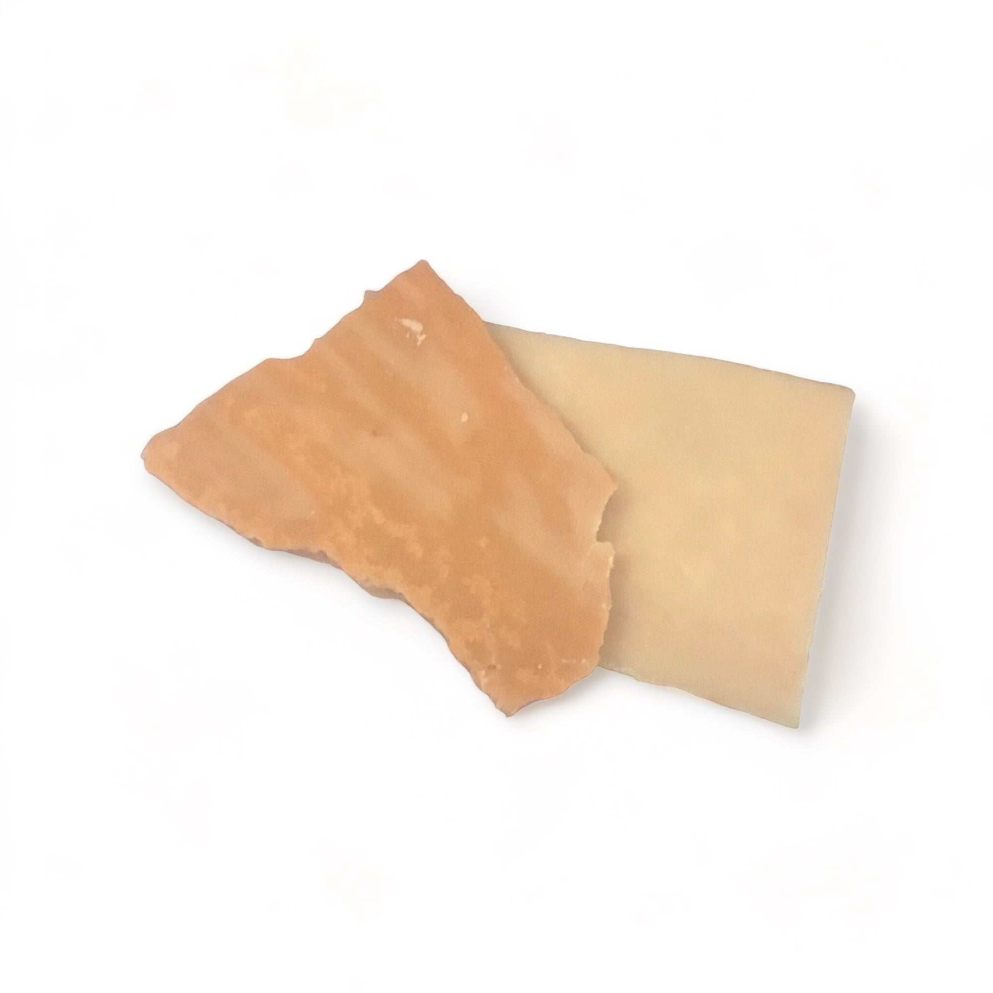 Two ounces of pale burnt orange colored wax melts in bark form on a white background