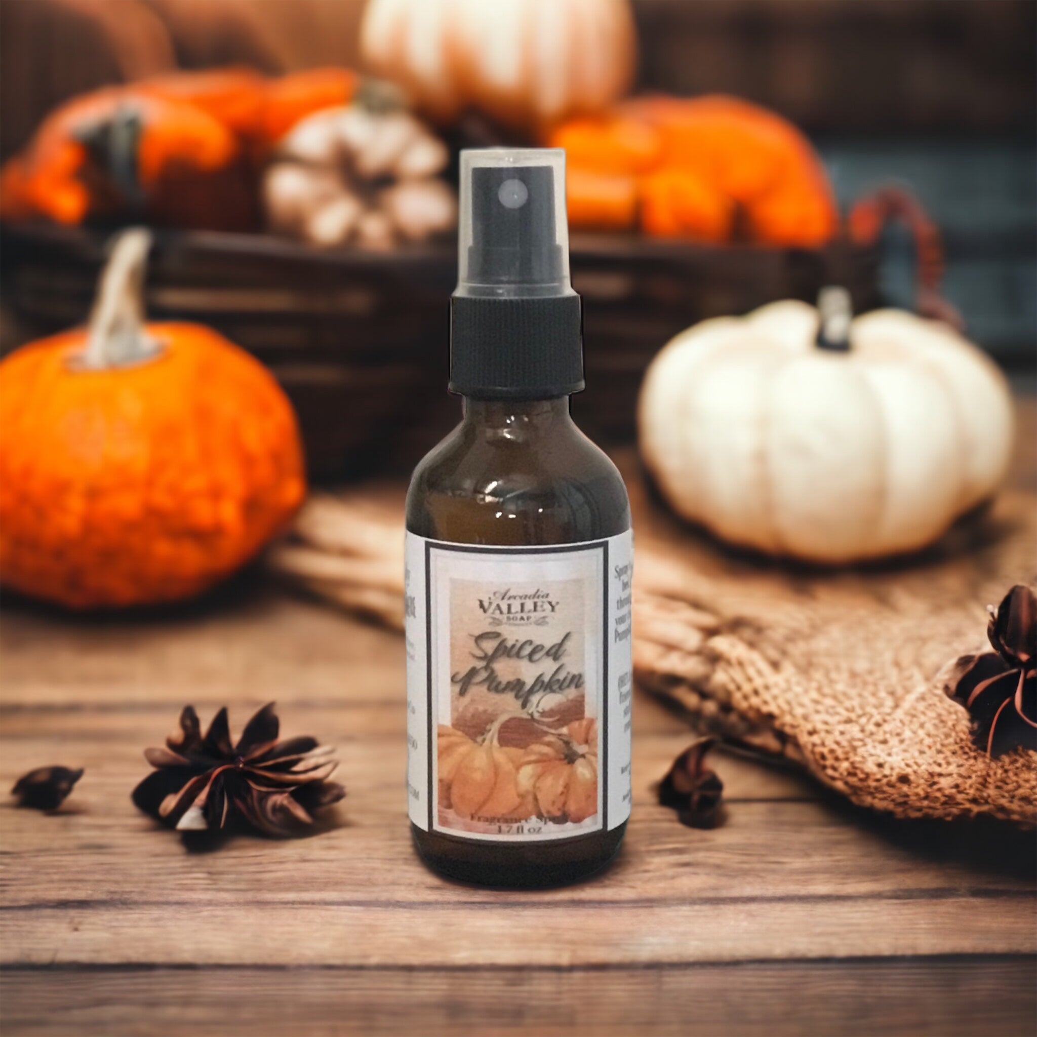 Spiced Pumpkin Spray in an amber glass bottle with mister top on a wooden table with pumpkins and spices displayed