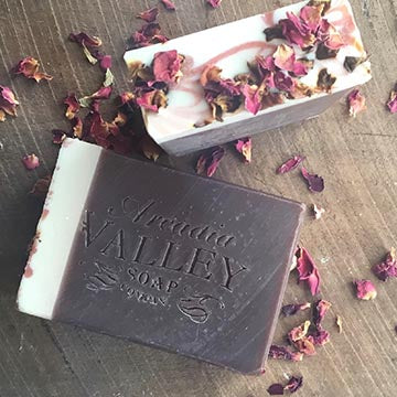 Arcadia Valley No19 Soap Bar showing logo stamp and tops of soap bar with dried petals on wooden board